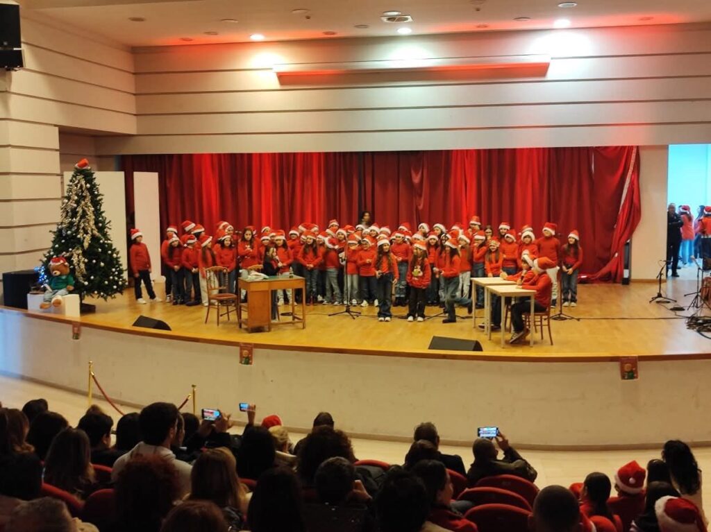 Il coro sul palco davanti al sipario rosso