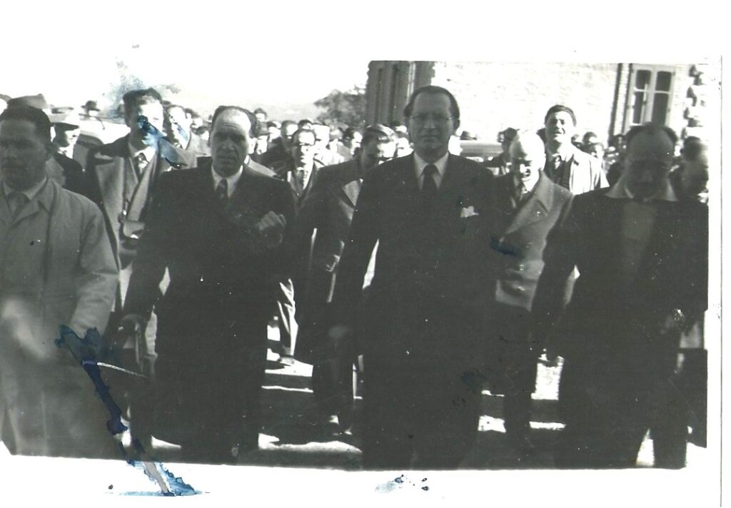 Foto d’archivio in bianco e nero di una visita istituzionale con autorità e folla